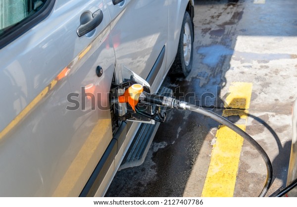 Gas pump nozzle on the car refilling\
fuel to the vehicle. Pumping fuel for a\
automobile