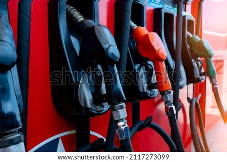 Gas pump nozzle in petrol station. Fuel nozzle in oil dispenser. Fuel dispenser machine. Refueling fill up with petrol gasoline and diesel. Petrol industry and service. Petroleum oil consumption.