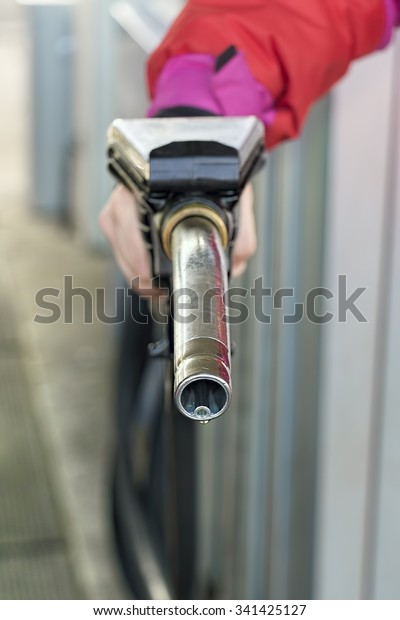 Gas pump\
nozzle prepared to refuel or tank\
up.