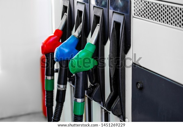 Gas pump nozzles in\
service station. Colorful Petrol pump filling nozzles, Gas station\
in a service.