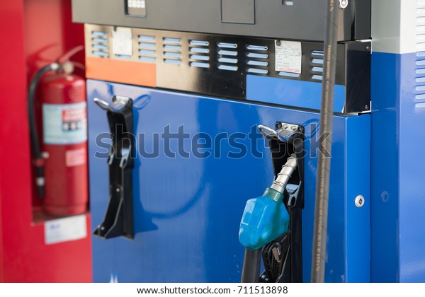 Gas pump nozzles in a service station, petrol\
pump filling