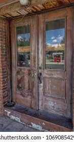 Gas pumps reflected in old wooden doors.