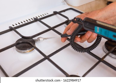 A Gas Safety Specialist Checks A Gas Stove In An Apartment Of A Residential Building For Leaks Of Household Gas Using A Measuring Device A Propane Analyzer