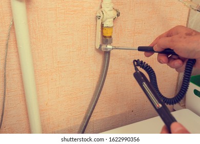 A Gas Safety Specialist Checks A Gas Stove In An Apartment Of A Residential Building For Leaks Of Household Gas Using A Measuring Device A Propane Analyzer