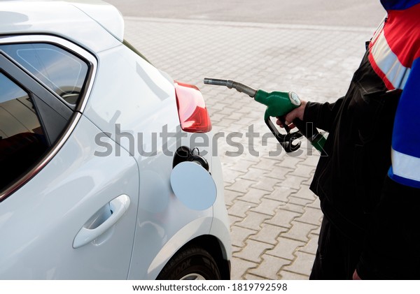 Gas station attendant at work. Car refueling on a\
petrol station