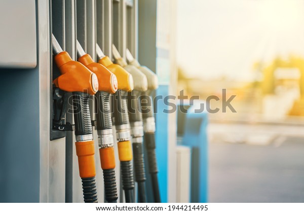 Gas station. Colorful petrol pump\
filling nozzles. Petrol station in a service in warm\
sunset.