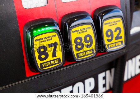 At a gas station multiple options are available for the type of gas to put in your vehicle and in this scenario the cheapest type of regular is selected since gas prices are rising and high.