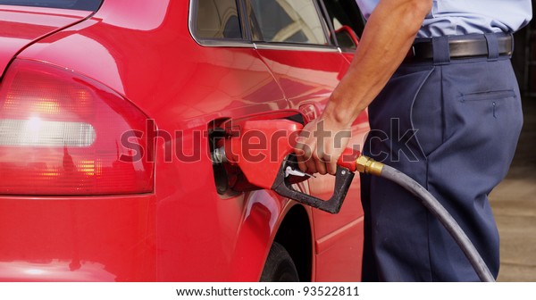 Gas\
station worker filling up car with fuel,\
closeup