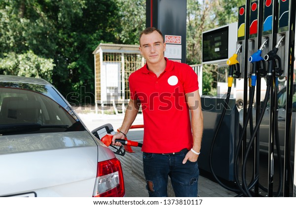Gas station worker\
refueling machine