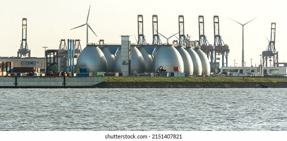 Gas storage reservoir, wind turbines and cranes in the harbour area in Hamburg, Germany  - Shutterstock ID 2151407821