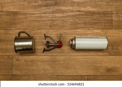 Gas Stove With Stainless Steel Mug On The Wood Background. Survival Equipment. Active Lifestyle Concept. Overhead View. Top View. Flat Lay.