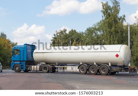 A gas tanker on a city highway follows the route to the place of unloading of dangerous goods for industrial use, for refueling cars and household appliances with blue fuel with a high octane rating