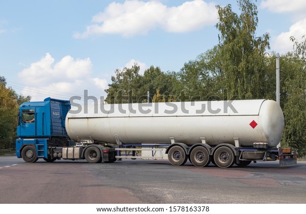 A gas tanker on a city highway follows the route\
to the place of unloading of dangerous goods for industrial use,\
for refueling cars and household appliances with blue fuel with a\
high octane rating
