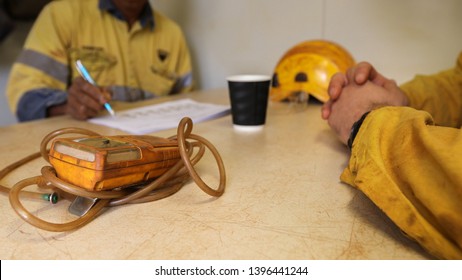 Gas Tester Atmosphere On Defocused Isolated Miner Workers Written Job Hazard Analysis (JHS) Risk Assessment On The Table When Working On Confined Restricted Space 