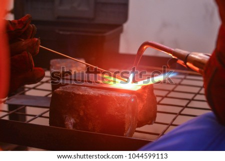 Gas welding using copper brazing rod technique. Soft focus & noise visible due to high ISO shallow DOF. 