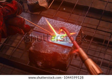 Gas welding using copper brazing rod technique. Soft focus & noise visible due to high ISO shallow DOF. 