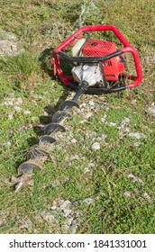 Gasoline Earth Auger On Green Grass In Garden
