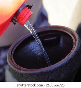 Gasoline Fuel Pouring From Plastic Gas Can Into Funnel Close Up. Preperation For Car Trip