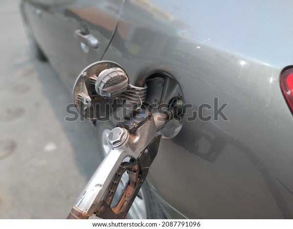 Gasoline pistol\
pump gun fuel nozzle and car on gas station, fuel monitoring system\
refueling petroleum to vehicle at gas station, Refill fuel in car\
at gas station, selective\
focus