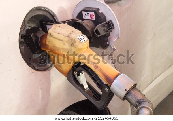 Gasoline pump refilling the automobile gasoline tank.\
Gasoline prices increasing. Petrol prices concept. Expensive petrol\
prices concept. Gas station background. Filling gasoline to the\
car