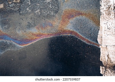 Gasoline Spill On Asphalt In A Car Park As A Texture Or Background.