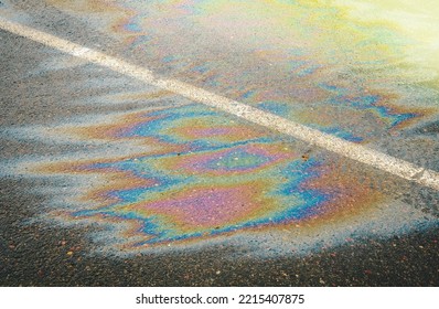 Gasoline Spill On Asphalt In A Car Park As A Texture Or Background. Soft Focus