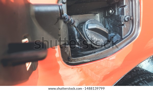 Gasoline tank with cover lid in the orange\
car background.