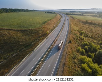 Gasoline Truck Oil Trailer On Highway Driving Along The Road. Aerial View Of Tank Vehicle At Work