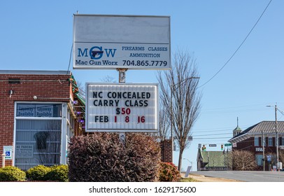 GASTONIA, NC, USA-26 JAN 2020: A Firearms And Training Store With Sign Advertising A NC Concealed Carry Class.  MGW, Mac Gun Worx Sells Firearms And Ammunition.