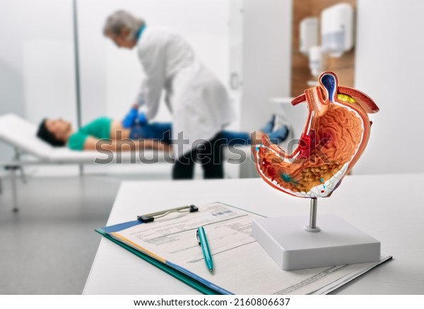 Gastroenterologist consultation, treatment of\
stomach diseases and ulcers. Doctor palpates woman patient abdomen\
and examines belly at\
clinic