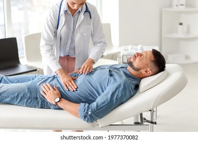 Gastroenterologist examining man in clinic - Shutterstock ID 1977370082