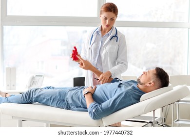 Gastroenterologist Examining Man In Clinic