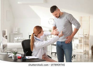 Gastroenterologist examining man in clinic