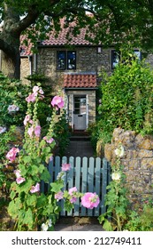 Gate And Pathway Leading To A Beautiful English Stone Cottage