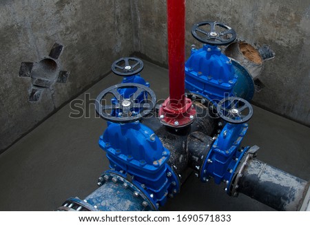 Gate valves in valve pit of the underground piping networks. Laying water system pipeline at construction site. Water supply pipeline, pipes in trench. Sewage pumping stations, stormwater, utilities