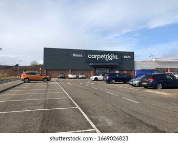 Gateshead, United Kingdom - March 10th 2020: Front on view of a Carpetright Beds and Flooring Superstore with cars parked in its car park. Set against a beautiful cloud filled blue sky.