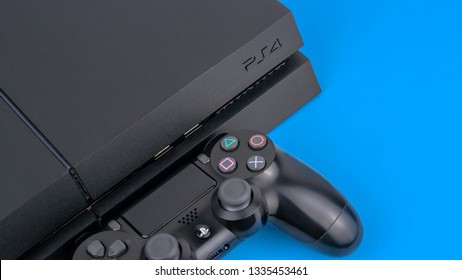 Gateshead, United Kingdom - March 11th 2019: Sony Playstation PS4 console including official Sony Dual Shock controller.  Studio shot and featured on a vibrant blue background.