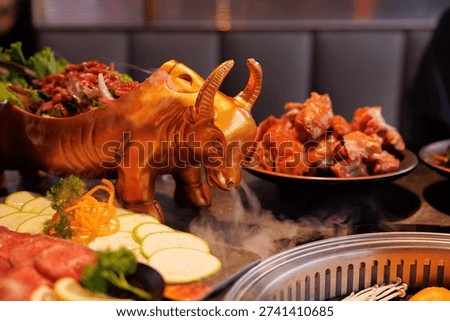 Gathered for a vibrant dining experience, diners enjoy a stunning gold bull dish filled with fresh meat and greens.