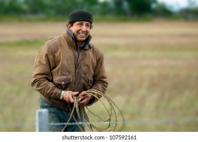 Gaucho, Carlos Martinez, Rides With Two Sheep Dogs Heading Toward Herd In Chile, South America