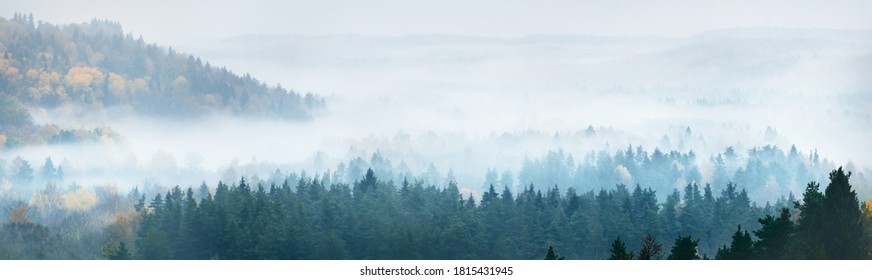 Gauja river valley and pine forest in a clouds of thick mysterious morning fog at sunrise. Sigulda, Latvia. Breathtaking panoramic aerial view. Pure nature, environmental conservation, eco tourism - Shutterstock ID 1815431945