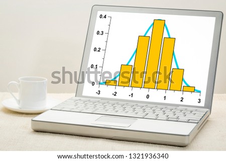 Gaussian, bell or normal distribution curve and histogram on laptop computer  with a cup of coffee