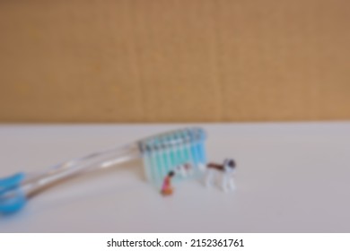 Gaussian Blur Image Of Miniature Dog And People With Tooth Brush