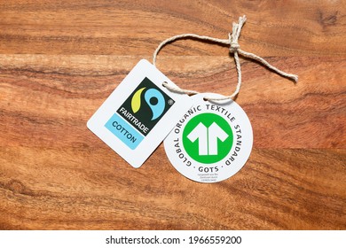 Gauting, Germany - Apr 20, 2021: Fairtrade Cotton And GOTS (Global Organic Textile Standard) Label On Wooden Background.