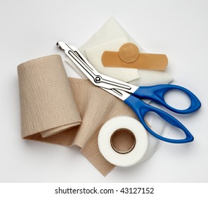 Gauze, Ace Bandage, Tape, Scissors And Bandages Shot On White Background With A Soft Shadow