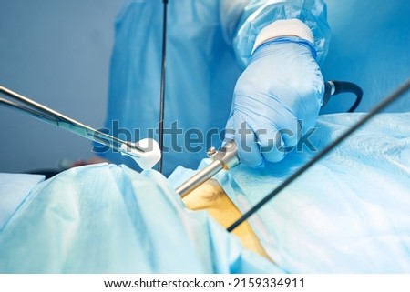 Gauze in surgical forceps moving to abdomen incision during operation
