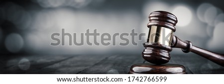 Gavel And Block On Wooden Desk With Bokeh Background - Law And Justice / Auction Concept