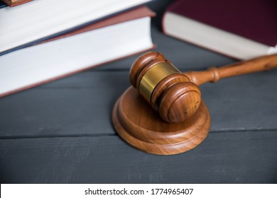 Gavel and books on wooden table background