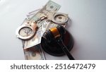 Gavel hammer, US dollar banknotes and handcuffs on white background. concept of bribing judges, court system, law and crime