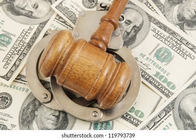 Gavel and handcuffs on money background - Shutterstock ID 119793739