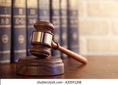 Gavel leaning against a row of law books - Shutterstock ID 420591208